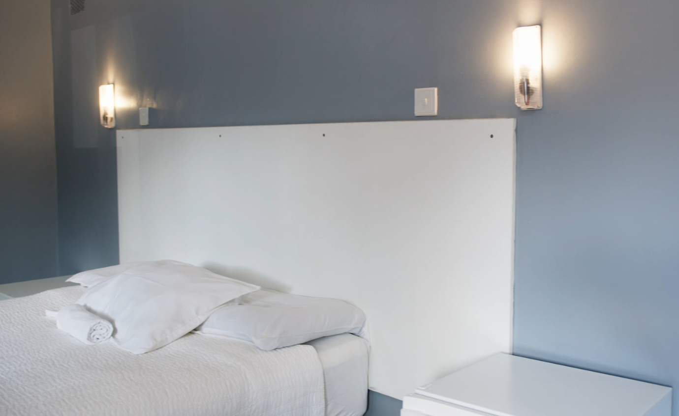 Made-up bed with bedside lighting